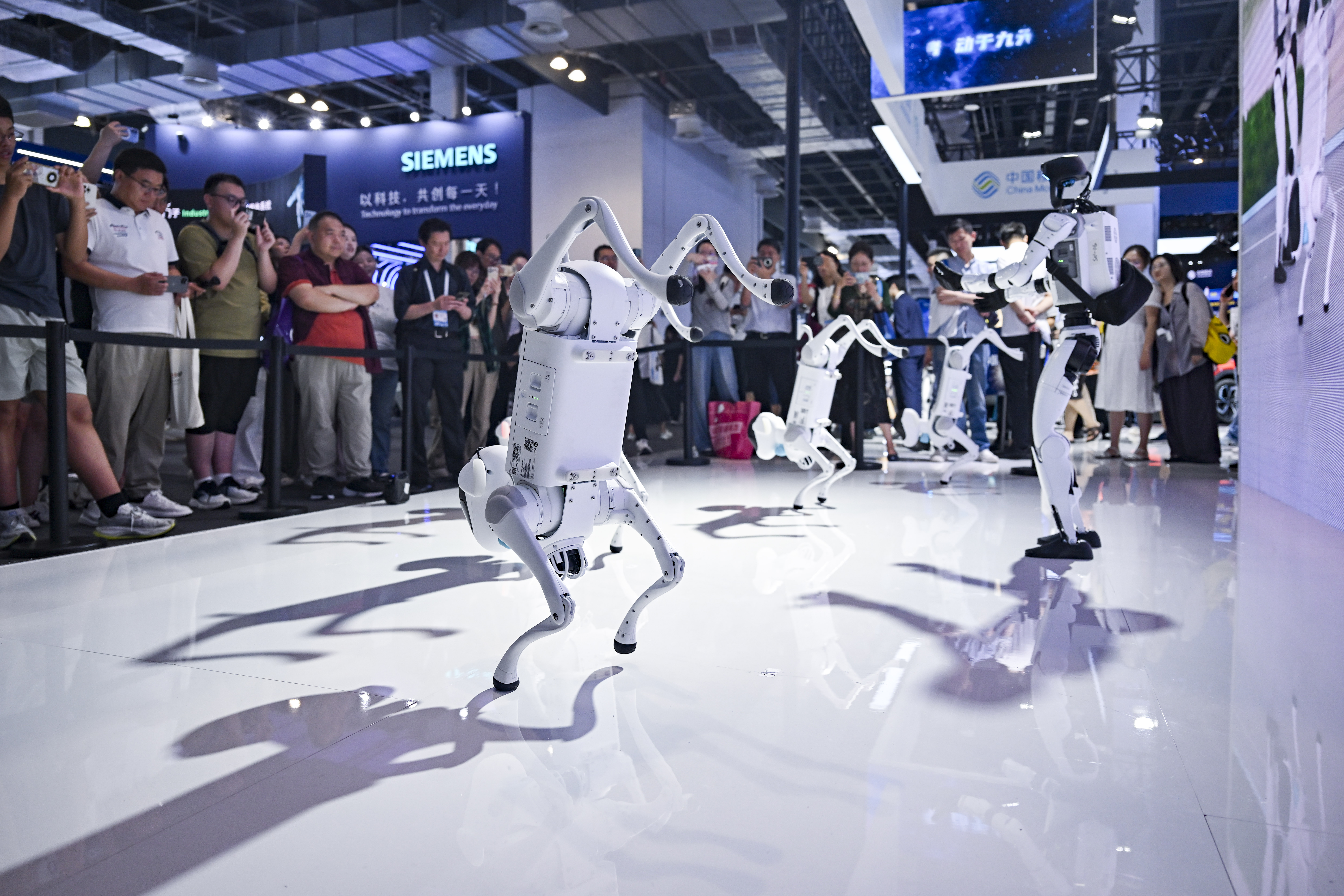 차이나모바일의 자체 개발 로봇 개들과 휴머노이드 로봇이 2025년 7월 27일(현지시간) 중국 상하이에서 열린 '2025 세계 인공지능 콘퍼런스' 차이나 모바일 부스에서 춤을 추고 있다. /사진=신화/뉴시스