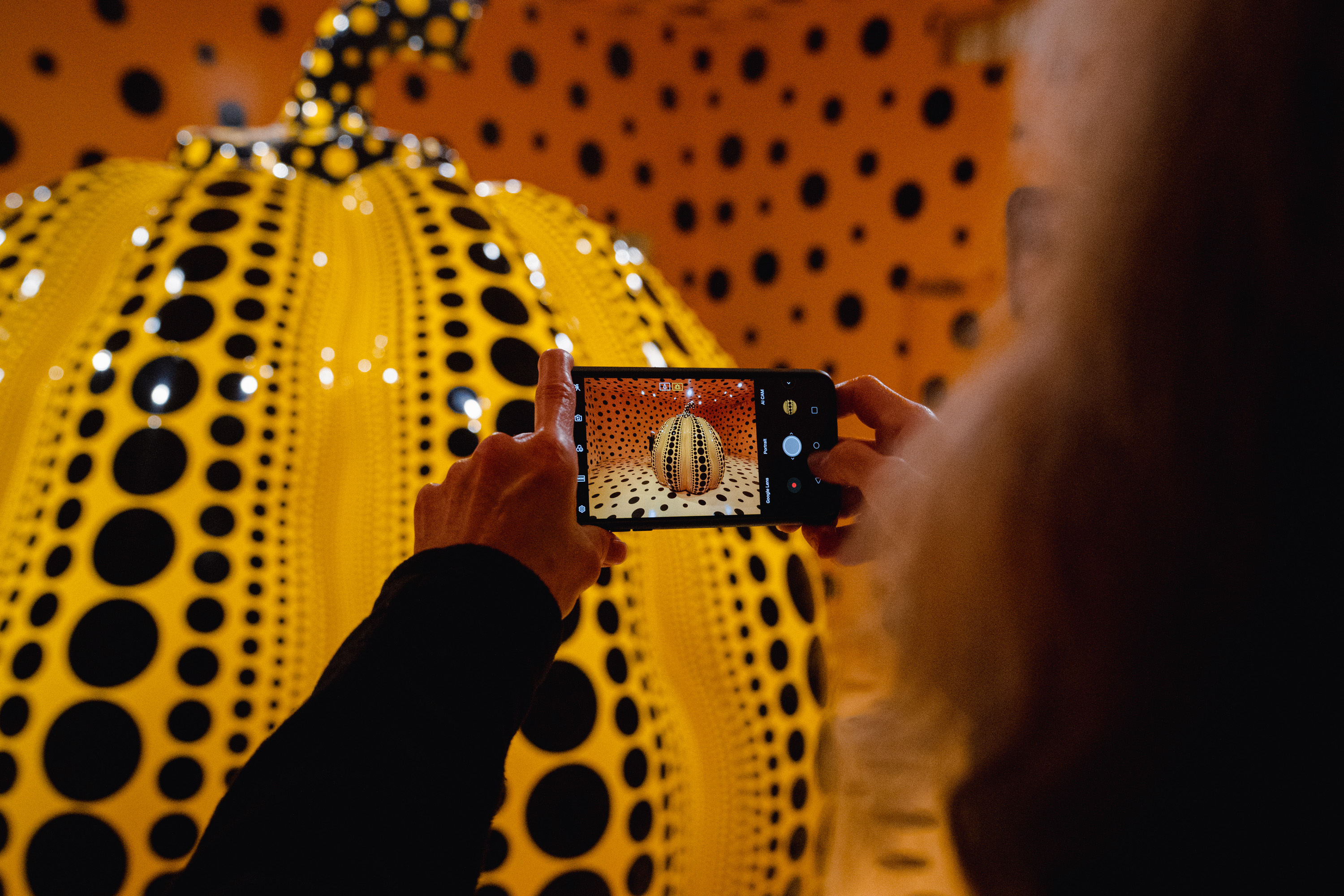 한 관람객이 2022년 허쉬혼 미술관에서 쿠사마의 대형 조각〈호박(Pumpkin)〉을 촬영하고 있다. (Shuran Huang/For The Washington Post)