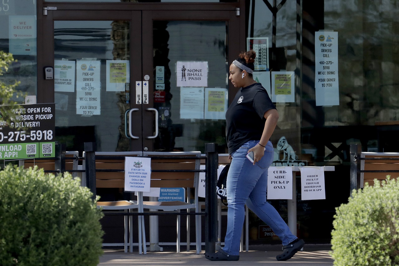 (▲ 미국 애리조나주 피닉스에서 한 사람이 당분간 영업을 중단하고 포장만 가능하다고 공지한 식당 앞을 지나고 있다. 코로나19 여파로 미국 곳곳이 식당 영업을 제한하고 있다. 출처 : AP/뉴시스)