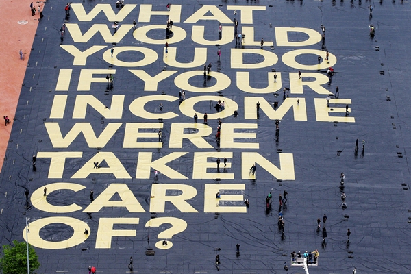 2016년 스위스 제네바 플랭팔래 광장에서 기본소득 지급 안건을 찬성하는 사람들이 "소득이 보장되면 무엇을 하실 건가요?"라고 적힌 대형 현수막을 설치하고 있는 모습. /사진=AP 뉴시스
