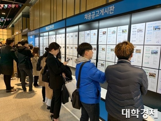 취준생들이 채용공고게시판에 붙은 기업의 채용설명서를 보고 있다.